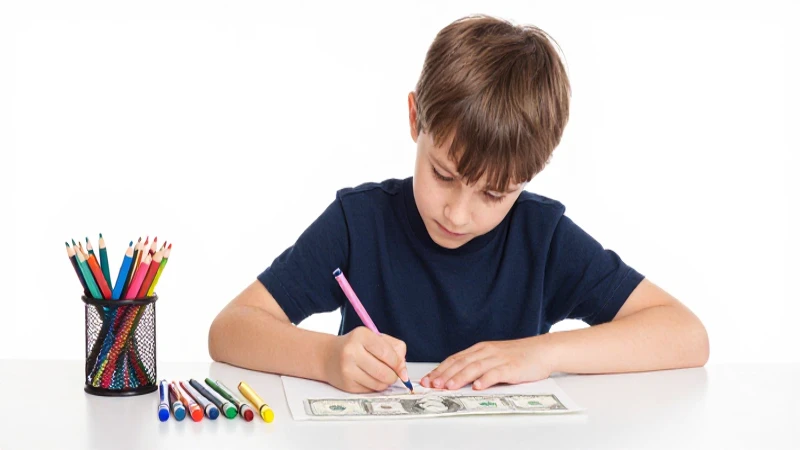 Niño dibuja dinero con crayones coloridos