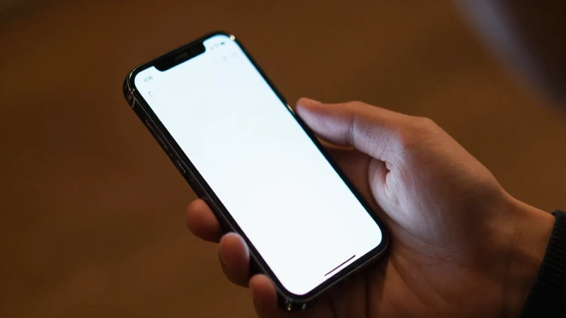 Manos sostienen un smartphone iluminado