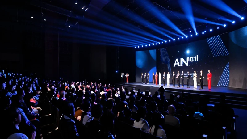 Evento formal, escenario iluminado y gran audiencia.