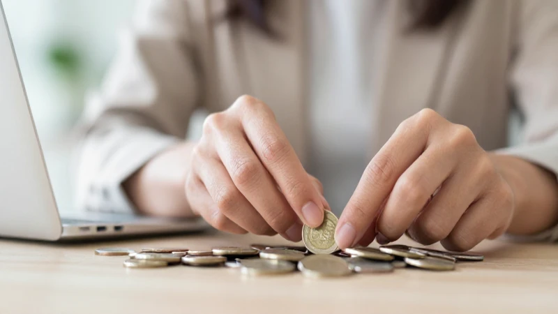 Mujer cuenta monedas en un banco.